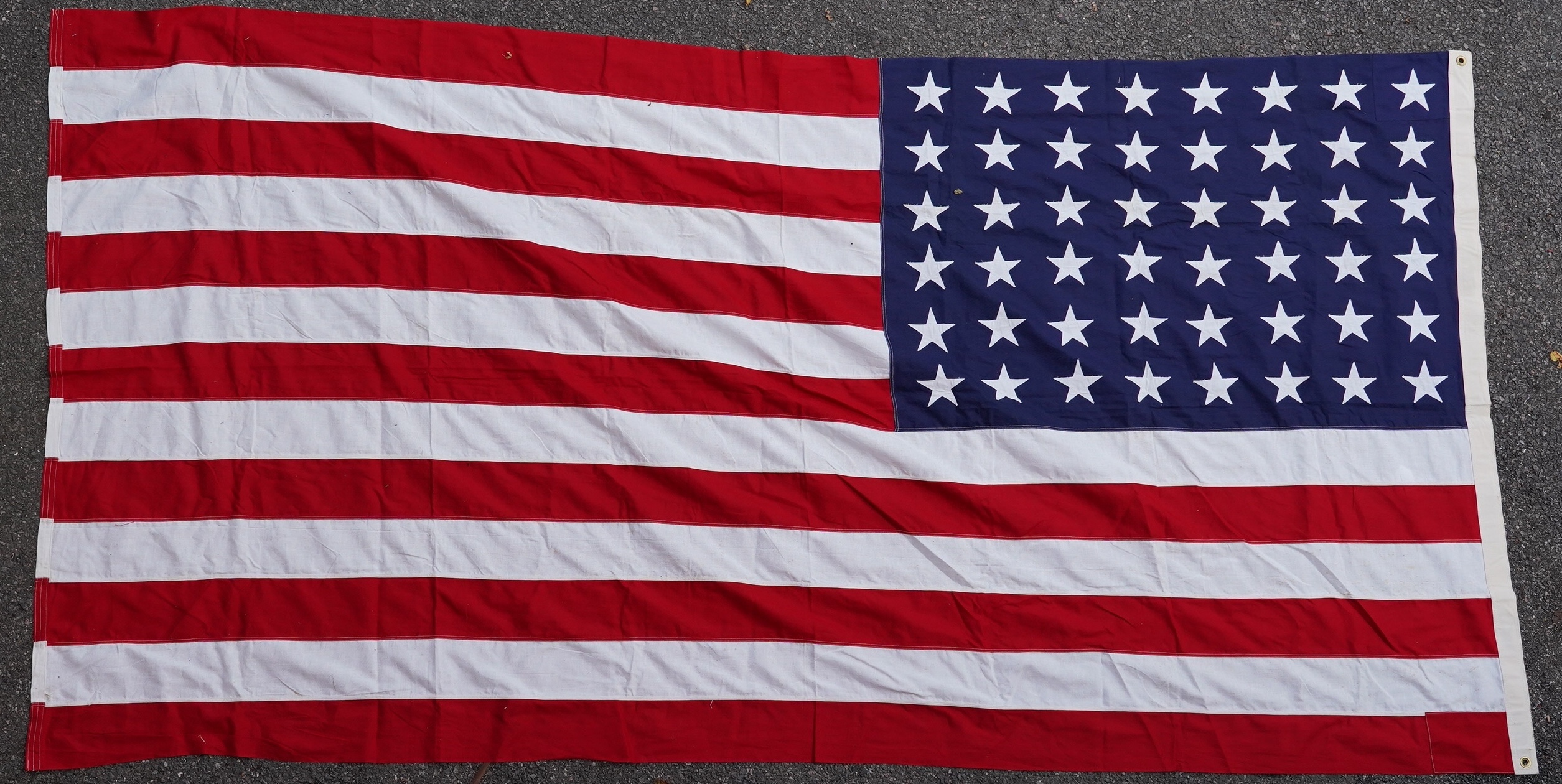 Four flags; two professionally made US Stars and Stripes, both on thick canvas with applied stars and joined stripes, one by the Valley Forge Flag Co., Pennsylvania, stamped “5 x 9.5 ft”, 146 x 288cm and 176 x 300cm, tog